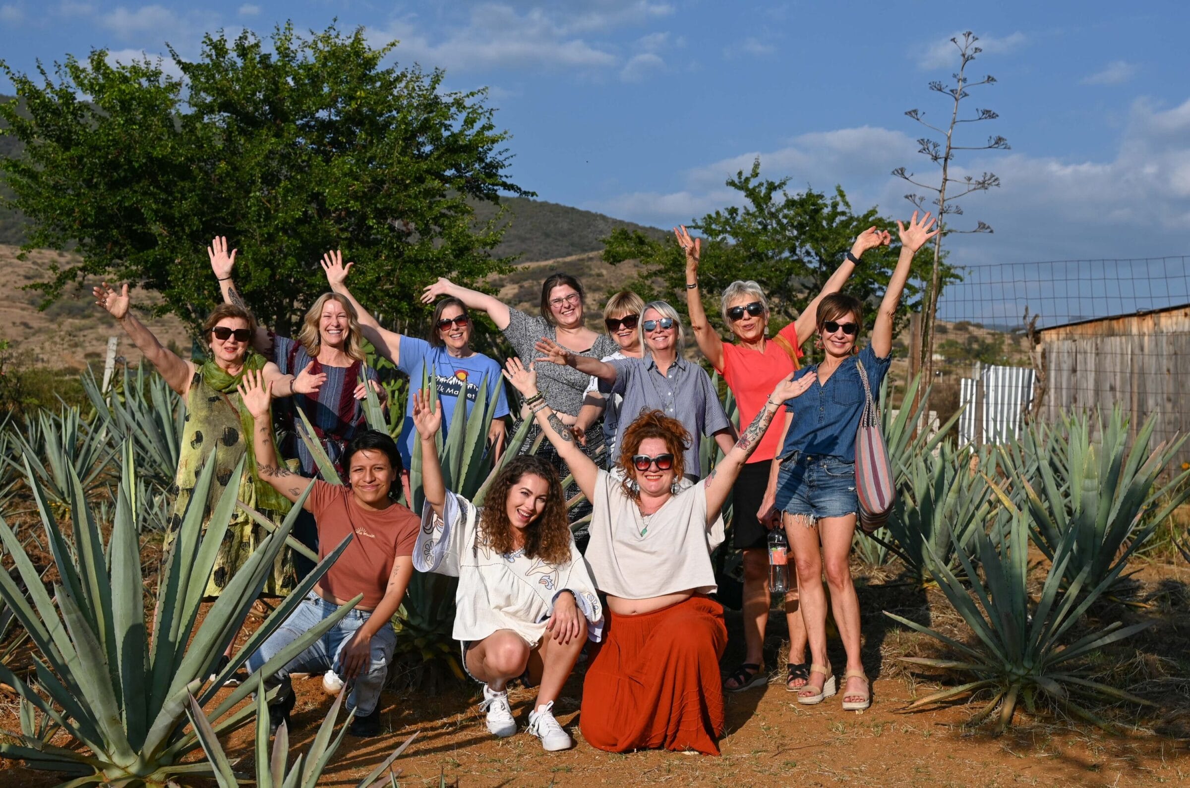 Group posing in field of agave at mezcaleria in Matalán, Mexico